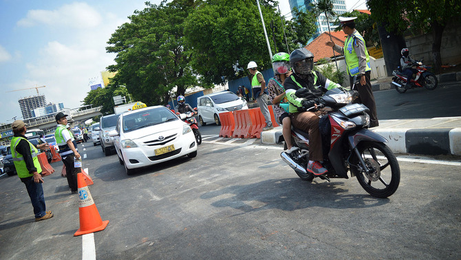 Sejumlah petugas mengatur lalulintas di jalan layang (flyover) sisi selatan Kuningan, Jalan Gatot Subroto, Jakarta Selatan, 30 Desember 2015.