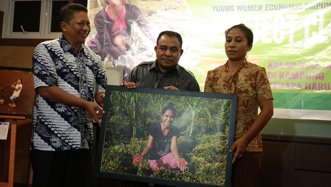 Dari kiri, Deputi Direktur Plan Internasional Indonesia, Nono Sumarsono bersama Bupati Timor Tengah Utara, Raymundus Sau Fernandes menyerahkan foto kepada  Petani perempuan binaan Plan yang sukses dalam mengembangkan pertaniannya, Marcelina disela pameran foto dengan tema 