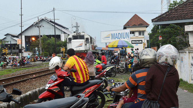 Sejumlah orang melihat Kereta Api (KA) yang melintas sambil menunggu saat berbuka puasa (ngabuburit) di dekat Stasiun KA Madiun, Jawa Timur, 6 Juni 2016. Pada hari pertama puasa Ramadan, banyak umat muslim bersama keluarganya ngabuburit di sekitar stasiun KA Madiun. Antara/Siswowidodo