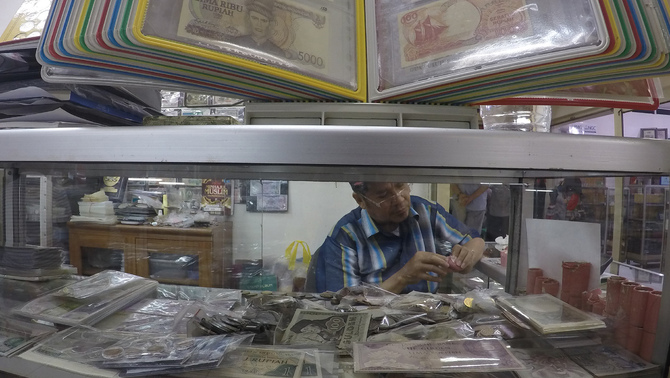 Penjual koleksi uang yang berdagang uang-uang specimen di pusat perbelanjaan Jakarta Pusat, Senin 9 Mei 2016. Bisnis jual uang specimen memiliki pasar khusus yaitu para kolektor uang specimen. Uang specimen sangat berharga jika tahun produksinya yang lama tetapi kondisinya masih bagus. Investor Daily / Emral Firdiansyah