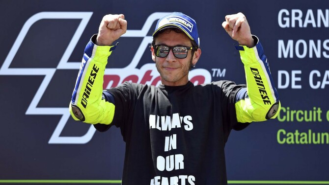 Pembalap Movistar Yamaha Valentino Rossi merayakan kemenangan di GP Catalunya, 5 Juni 2016, dengan mengenakan kaos solidaritas untuk pembalap Moto2 Luis Salom yang tewas di sirkuit yang sama dua hari sebelumnya. 