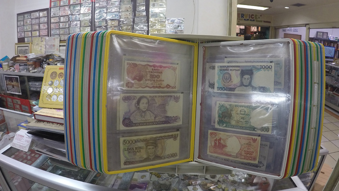 Penjual koleksi uang yang berdagang uang-uang specimen di pusat perbelanjaan Jakarta Pusat, Senin 9 Mei 2016. Bisnis jual uang specimen memiliki pasar khusus yaitu para kolektor uang specimen. Uang specimen sangat berharga jika tahun produksinya yang lama tetapi kondisinya masih bagus. Investor Daily / Emral Firdiansyah