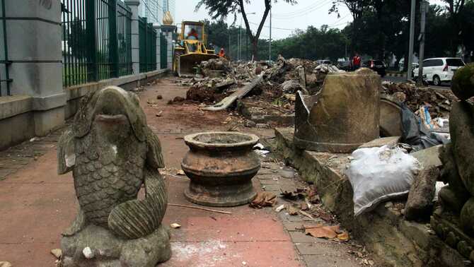 Alat berat membersihkan sisa-sisa pembongkaran bangunan tempat usaha tanaman hias di atas trotoar di kawasan Senayan, Jakarta, 7 Juni 2016.
