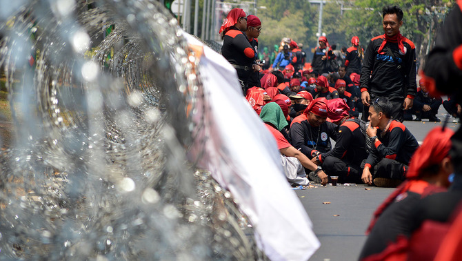 Ratusan buruh dari berbagai organisasi beristirahat di sela aksi penyampaian pendapat di depan Istana Negara, Jakarta, 1 September 2015. BeritaSatu Photo/Danung Arifin