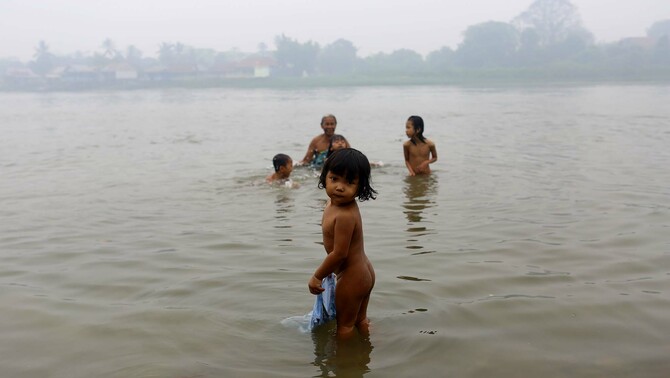 Sejumlah warga dan anak-anak mandi di tepian sungai Musi, Palembang, Sumatra Selatan, 30 Oktober 2015.
