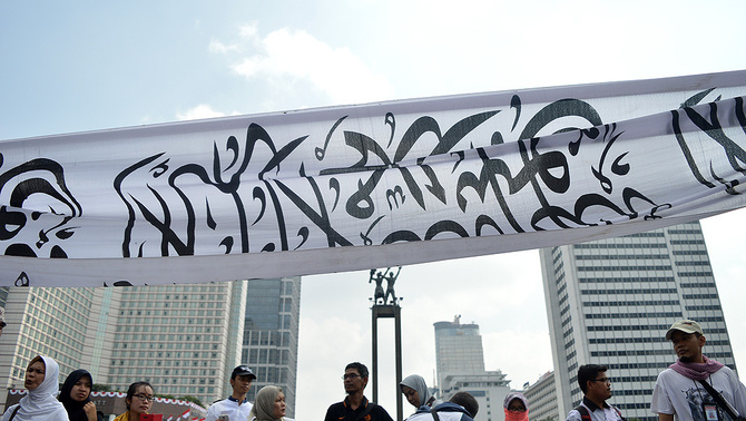 Ribuan masa yang tergabung dalam ormas Islam se-Indonesia melakukan pawai dengan membentangkan banner bertuliskan lafal Tauhid dan mengibarkan bendera di Jakarta, 16 Agustus 2015.