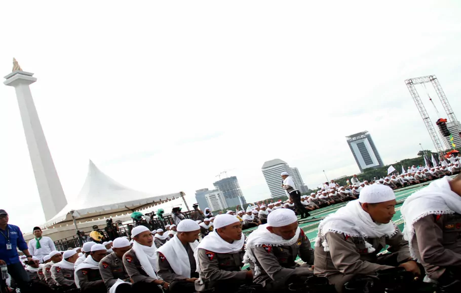 Aksi polisi yang mengenakan peci putih dan sorban mampu menyedot perhatian puluhan ribu umat Islam yang memadati kawasan Monas, Jakarta, Jumat, 2 Desember 2016.