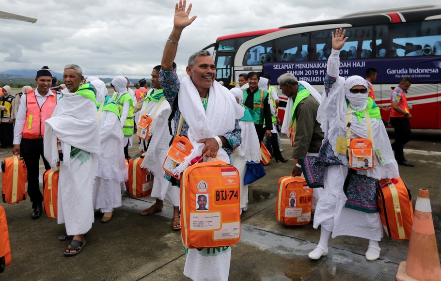 Sejumlah jemaah calon haji kloter pertama Embarkasi Aceh melambaikan tangan sebelum naik ke pesawat udara di Bandara internasional Sultan Iskandar Muda, Aceh Besar, Aceh, Sabtu (20/7/2019). Pemberangkatan jemaah calon haji dari Provinsi Aceh yang terbagi dalam 12 kloter akan berakhir pada 4 Agustus mendatang. 