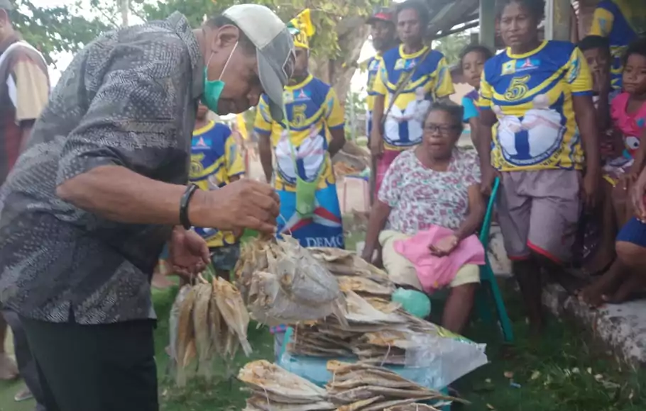 Calon Bupati Supiori, Yan Imbab, saat membeli  ikan asin dari mama-mama penjual asal Supiori di Kampung Insumbabi.
