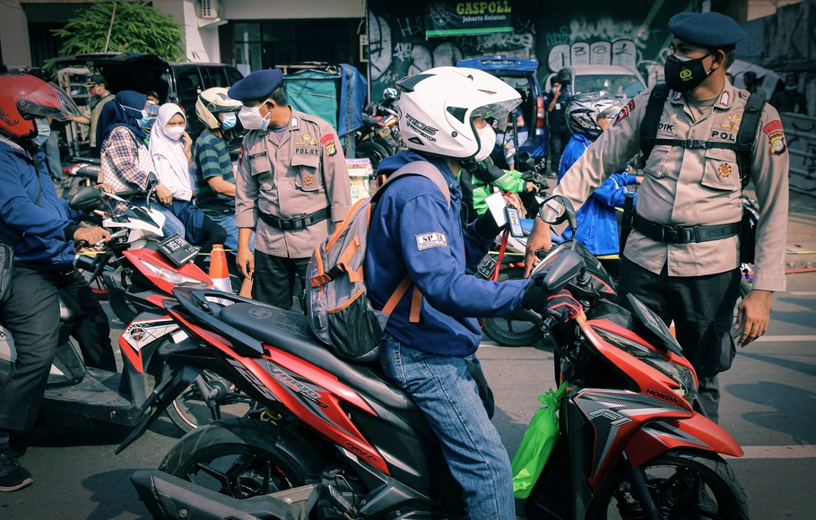 Petugas gabungan TNI-Polri mengecek STRP (Surat Tanda Registrasi Pekerja) kepada pengendara yang antre melintas di pos penyekatan underpass Mampang, Jakarta Selatan, Kamis, 15 Juli 2021.
