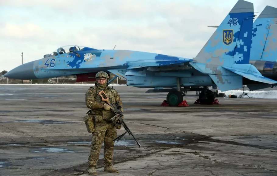 Seorang prajurit menjaga pesawat SU-27 Ukraina di pangkalan udara Ozerne, di wilayah Zhytomyr, Ukraina utara pada 6 Desember 2018.