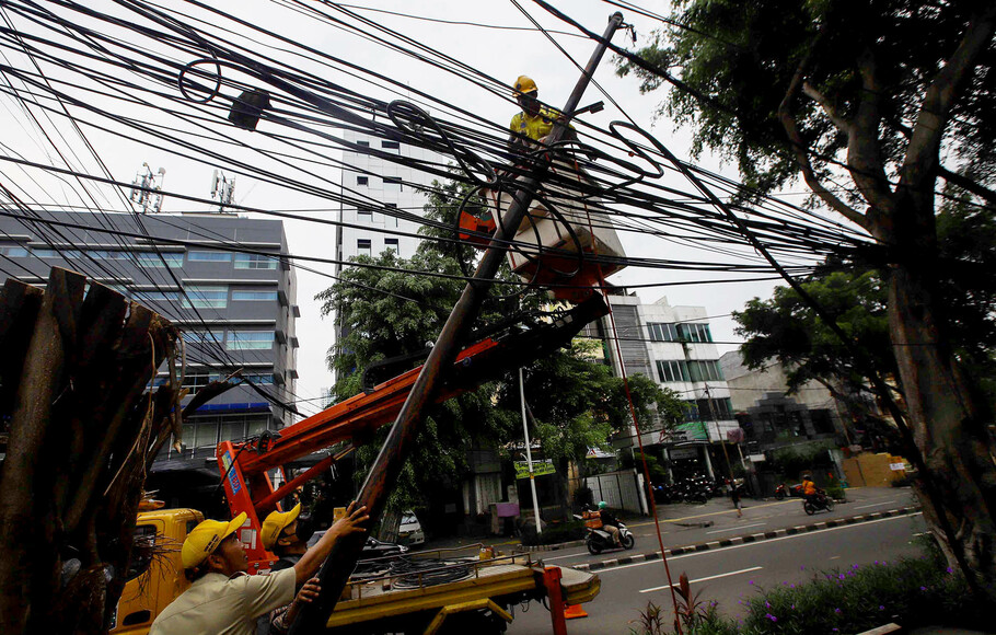 Petugas Dinas Penerangan Bina Marga DKI Jakarta merapikan kabel yang semrawut di kawasan Jalan Wahid Hasyim, Jakarta Pusat, Jumat, 18 Maret 2022.