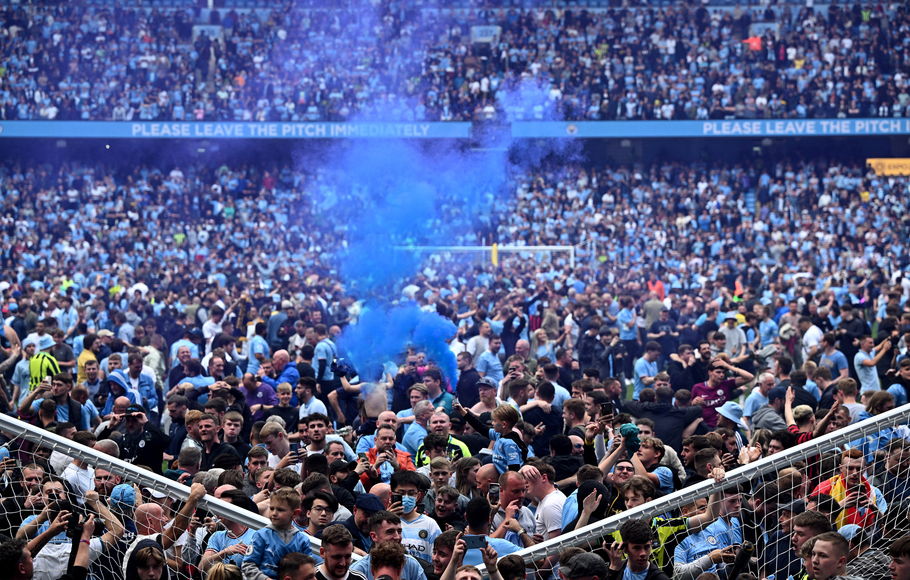 Pendukung Manchester City masuk lapangan merayakan kemenangan timnya menjuarai Premier League setelah mengalahkan Aston Villa di Etihad Stadium, Senin, 23 Mei 2022 dini hari WIB.