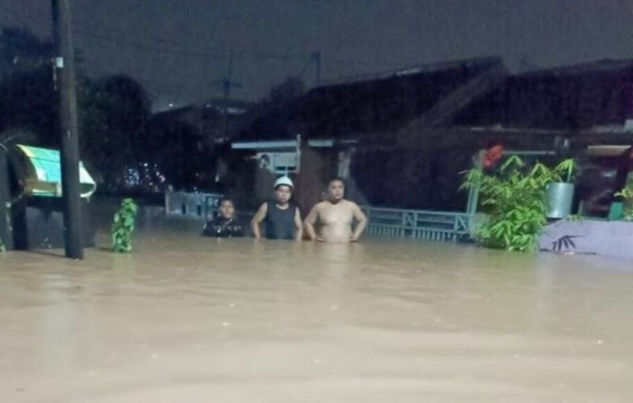 Sejumlah warga berjalan melewati genangan banjir di Perumahan Bumi Pesanggrahan Indah (BPI) di Desa Cilebut Barat, Sukaraja, Kabupaten Bogor, Jawa Barat, Jumat, 15 Juli 2022.