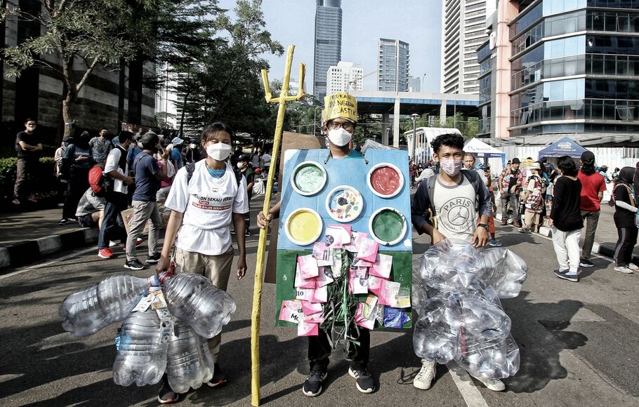 Sejumlah pegiat lingkungan membawa poster dan instalasi ular dari sampah plastik kemasan saat pawai bebas sampah plastik di kawasan Sudirman, Jakarta, Minggu, 24 Juli 2022.