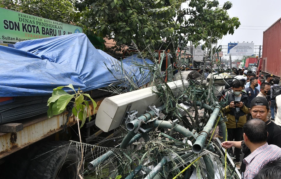 Warga melihat lokasi tempat kejadian kecelakaan sebuah truk kontainer yang menabrak halte bus di depan SDN Kota Baru II dan III di Jalan Sultan Agung, Bekasi, Jawa Barat, Rabu, 31 Agustus 2022.