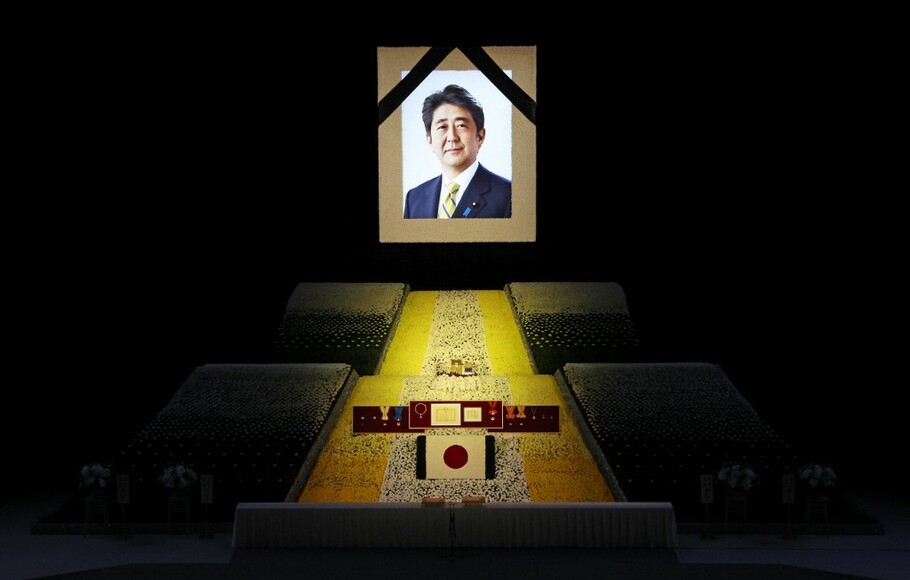 Potret mantan PM Jepang Shinzo Abe tergantung di atas panggung saat pemakaman kenegaraannya di Nippon Budokan di Tokyo pada 27 September 2022.