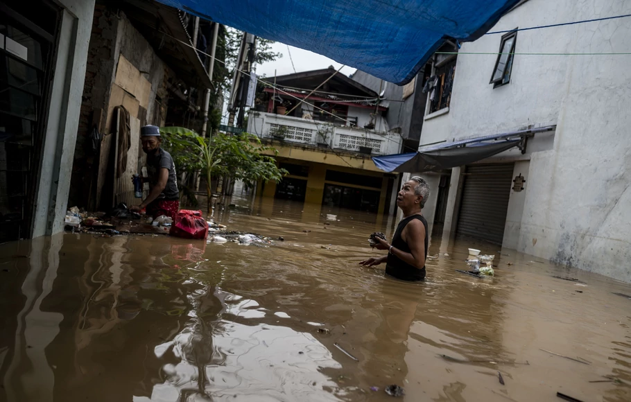 Warga berjalan melintasi banjir di permukiman penduduk kawasan Rawajati, Jakarta, Senin, 10 Oktober 2022.