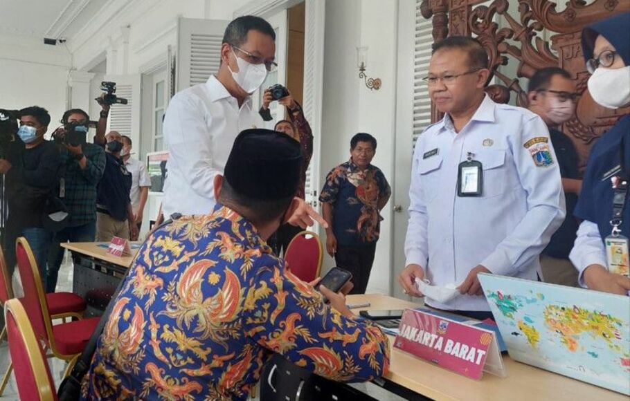 Penjabat Gubernur DKI Heru Budi Hartono (kiri) menyapa warga yang membuat pengaduan di posko pelayanan masyarakat di Pendopo Balai Kota Jakarta, Rabu 19 Oktober 2022