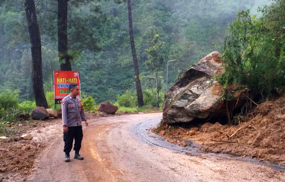 Polisi mengamankan jalur yang sebelumnya terdampak bencana longsor di Pamulihan, Kabupaten Garut, Jawa Barat, Jumat 25 November 2022.