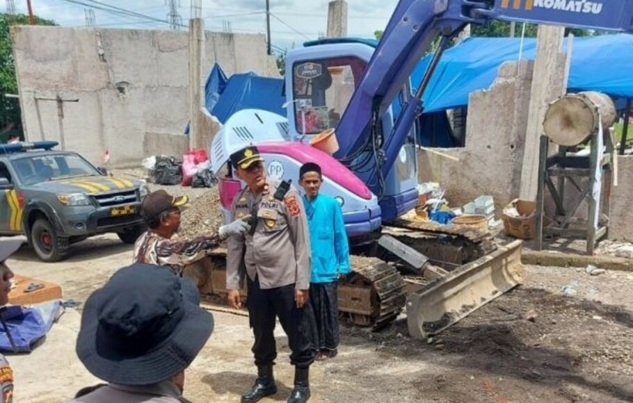 Polisi menurunkan alat berat untuk membersihkan puing bangunan masjid Al-Falah di Desa Nagrak, Kecamatan Cianjur, Jawa Barat yang ambruk akibat gempa Cianjur, Kamis 1 Desember 2022. 