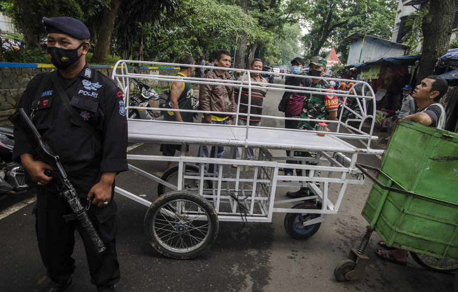 Tim Brimob Polri bersama warga menggunakan keranda mayat untuk menutup jalan usai peristiwa bom bunuh diri di Polsek Astanaanyar, Bandung, Jawa Barat, Rabu, 7 Desember 2022.