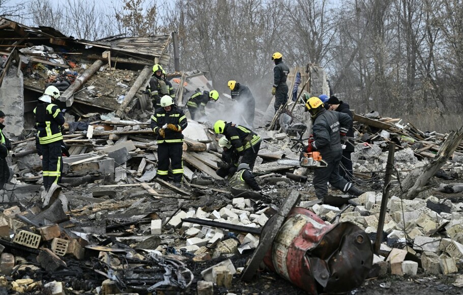 Tim penyelamat membersihkan puing-puing rumah yang hancur akibat serangan rudal di pinggiran Kyiv, Ukraina, pada 29 Desember 2022.