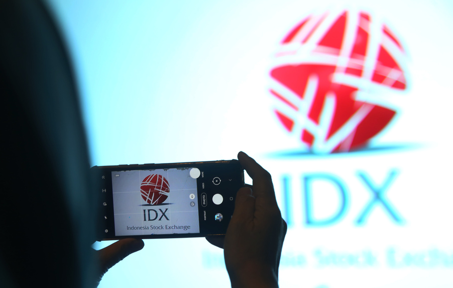 Pengunjung memotret menggunakan telepon seluler logo IDX di gedung Bursa Efek Indonesia (BEI), di Jakarta.