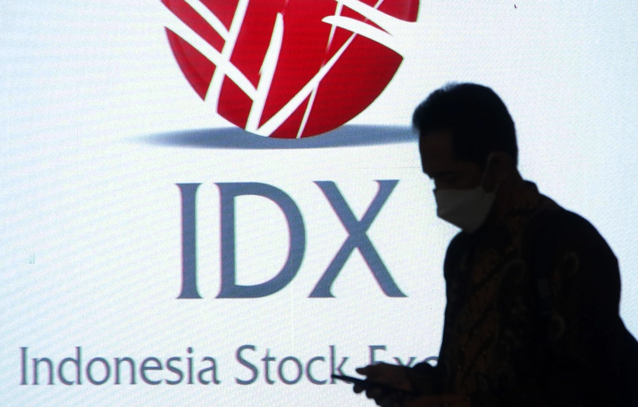 Pengunjung melintas di depan monitor logo IDX di Bursa Efek Indonesia (BEI), Jakarta.