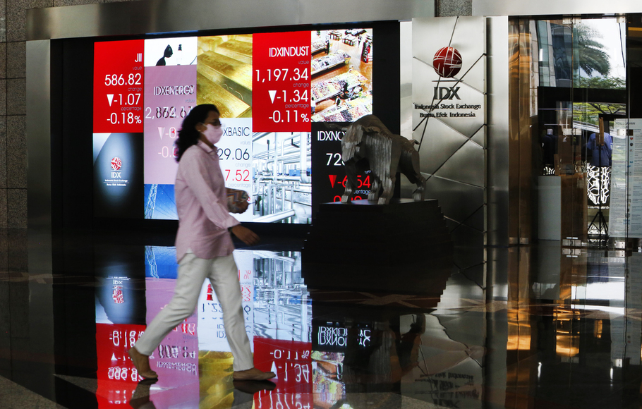 Pengunjung melintas di depan monitor saham Bursa Efek Indonesia (BEI), Jakarta.