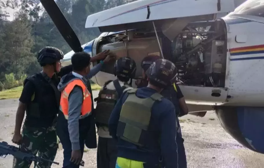 Aparat memeriksa lubang peluru di badan pesawat Asian One PK- LTF yang ditembak KKB di Bandara Beoga, Puncak, Papua, Jumat 14 April 2023.