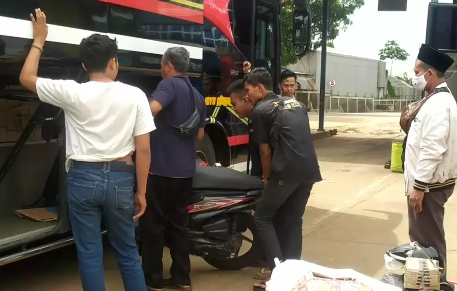 Pemudik Lebaran 2023 memasukkan motor ke dalam bus di Terminal Cileungsi, Bogor, Sabtu 15 April 2023.