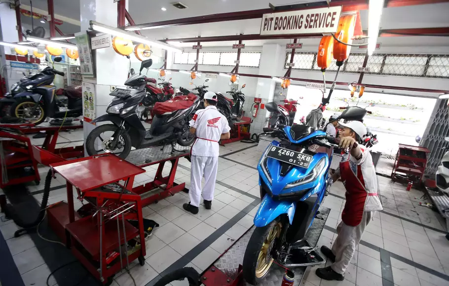 Mekanik melakukan perbaikan dan perawatan sepeda motor di sebuah bengkel di Ciputat, Tangerang Selatan, Banten, Selasa, 18 April 2023.