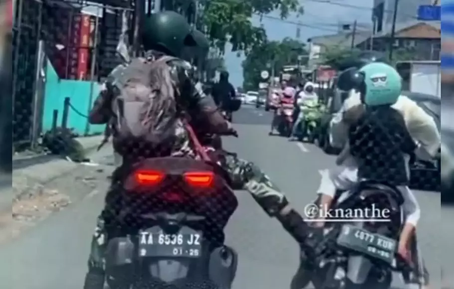 Pria berbaju loreng diduga oknum TNI menggunakan motor berpelat AA-6536-JZ menendang motor ibu-ibu yang memboncengkan seorang anak. Kejadian ini terekam kamera dan videonya viral di media sosial.