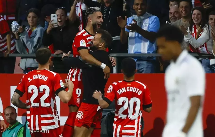 Pemain Girona, Valentin Castellanos (atas), meluapkan kegembiraan bersama rekan-rekannya setelah mencetak gol ke gawang Real Madrid di Stadion Montilivi, Girona, Selasa 25 April 2023. Photo Details