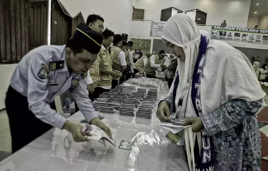 Petugas menyerahkan paspor jamaah calon haji lansia embarkasi Jakarta di Asrama Haji Pondok Gede, Jakarta Timur, Selasa 23 Mei 2023.
