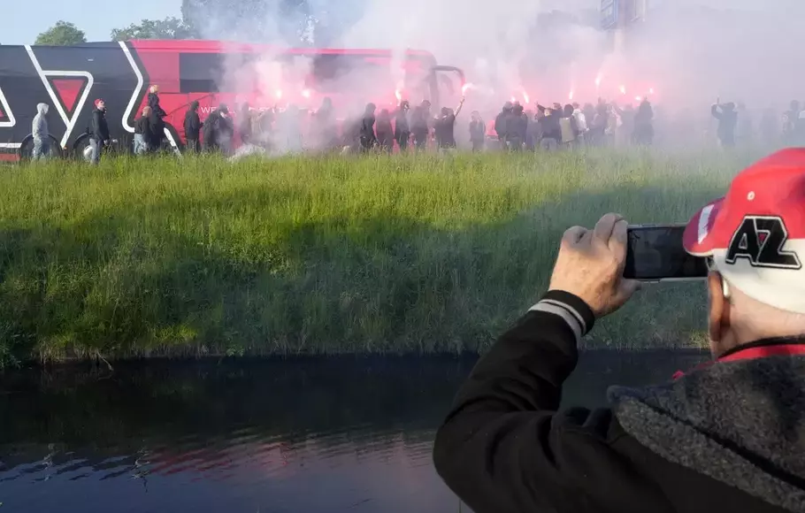 Pendukung AZ Alkmaar memegang suar, berlarian untuk mendekati bus pemain sebelum pertandingan sepak bola semifinal leg kedua Conference League melawan West Ham di stadion AZ di Alkmaar, Belanda, Kamis, 18 Mei 2023.