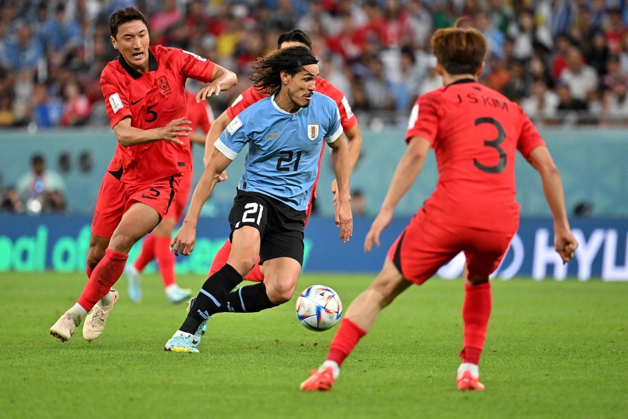 Aksi striker Uruguay, Edinson Cavani berusaha melewati adangan pemain Korea Selatan pada laga Grup H Piala Dunia 2022. - (AFP)