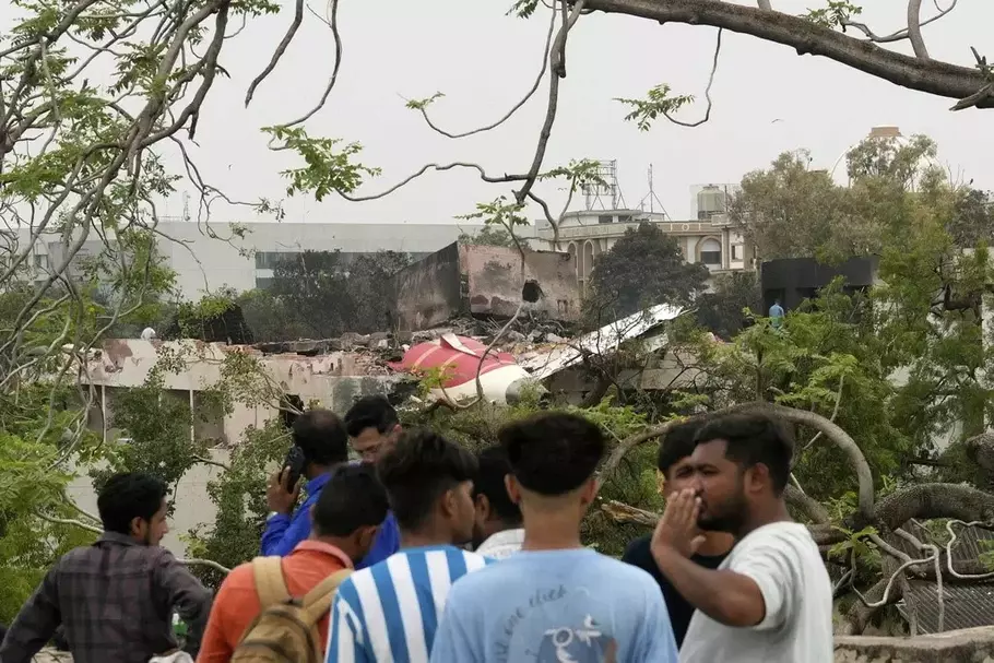 Orang-orang melihat bagian-bagian pesawat Air India yang jatuh pada hari Kamis di atas sebuah gedung di Ahmedabad, India, pada Jumat, 13 Juni 2025.
- (AP/AP)