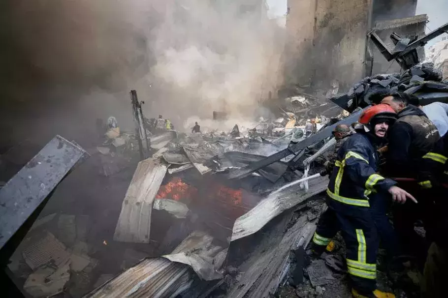 Petugas pemadam kebakaran, tim pertolongan pertama, dan sukarelawan bekerja memadamkan puing-puing yang masih berasap di lokasi serangan udara Israel yang menghantam sebuah gedung apartemen di Beirut, Lebanon, Rabu, 8 April 2026. - (AP/Bilal Hussein)