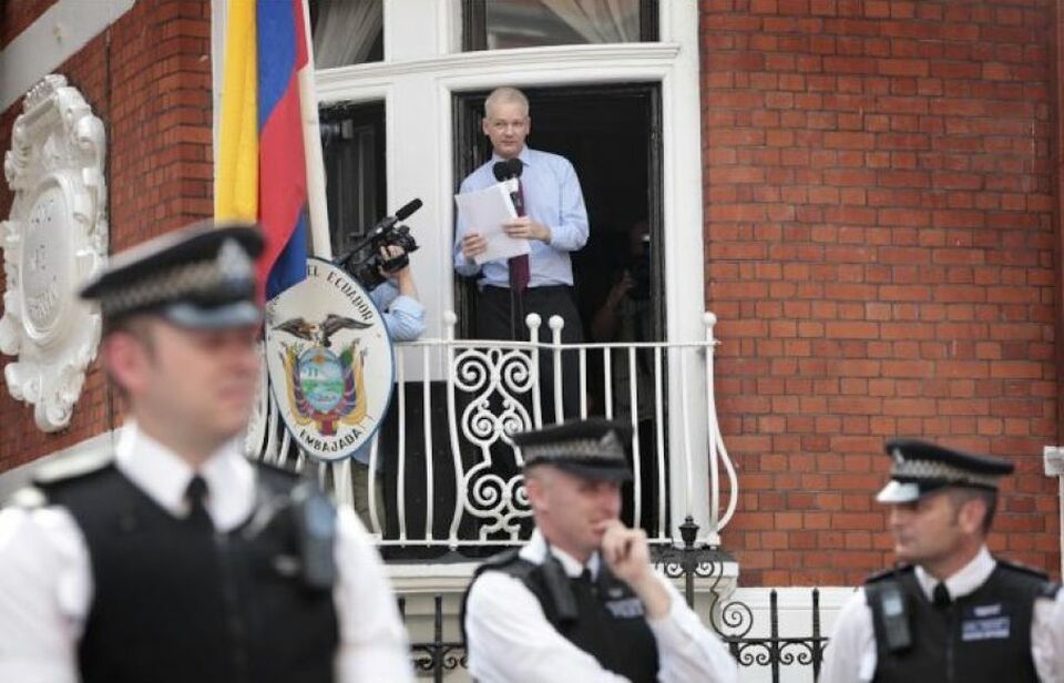 Di foto tertanggal 19 Ag. 2012 ini, Assange berpidato di gedung Kedutaan Ekuador sementara polisi Inggris yang ingin menangkapnya tak bisa berbuat apa-apa kecuali berjaga di lokasi. 