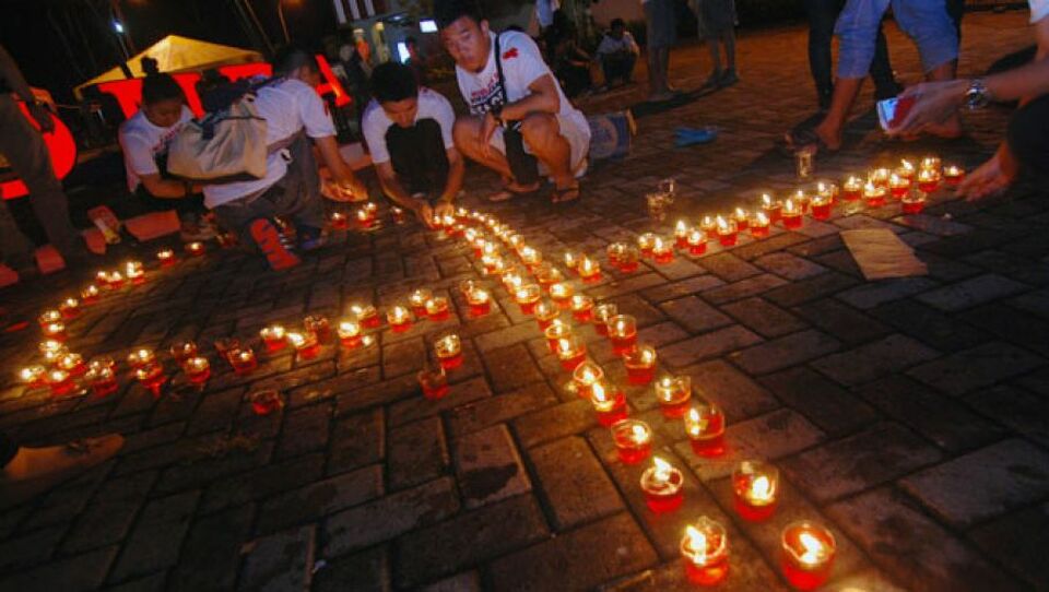 Sejumlah mahasiswa Politeknik Kesehatan (Poltekes) Universitas Sam Ratulangi menyalakan puluhan lilin saat malam renungan peringatan Hari Aids Internasional, di Manado, Sulawesi Utara, Minggu (1/12) malam.