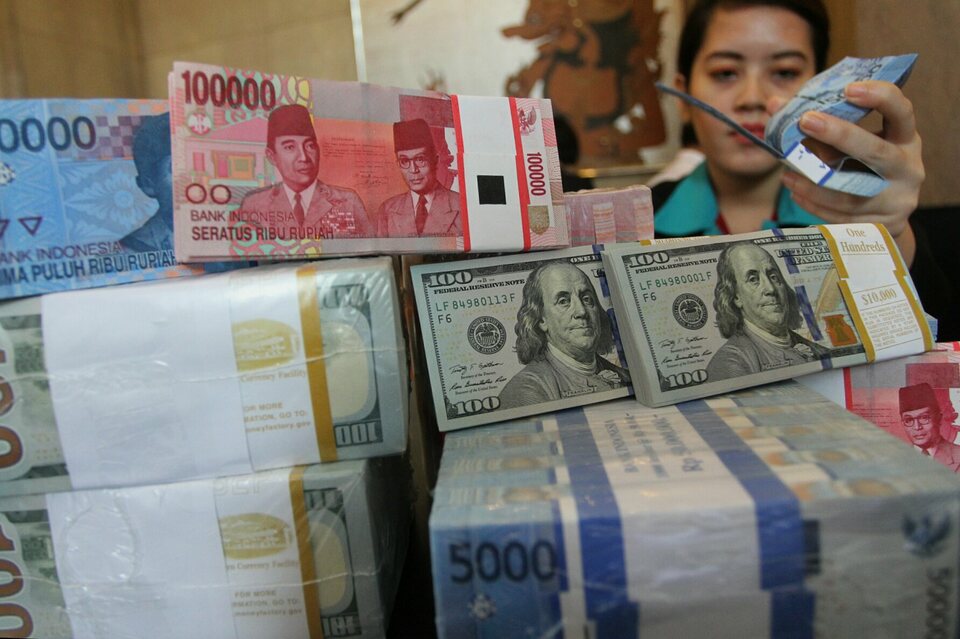 Teller Bank CIMB Niaga menata uang rupiah di Jakarta, Selasa (21/10). 