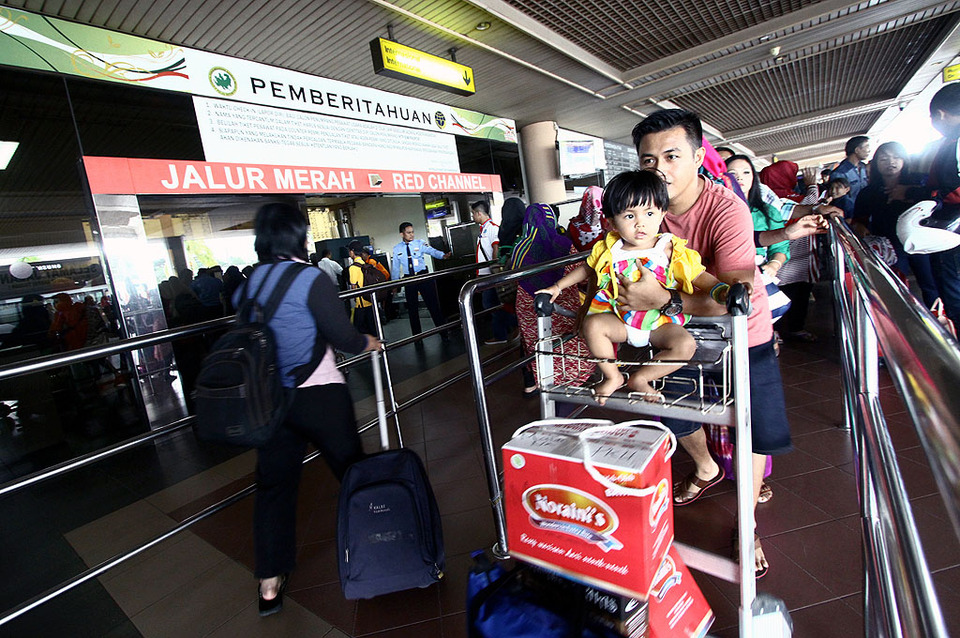 Sejumlah penumpang mengantre masuk di pintu keberangkatan Bandara Internasional Hang Nadim, Batam, Rabu (24/12). 
