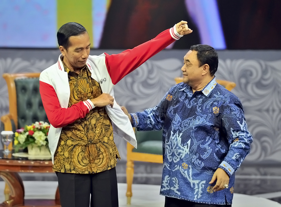 Presiden Joko Widodo (kiri) menerima jaket media dari Ketua Persatuan Wartawan Indonesia (PWI) Pusat Margiono (kanan) saat acara Silaturahim Pers Nasional di Jakarta, 27 April 2015.