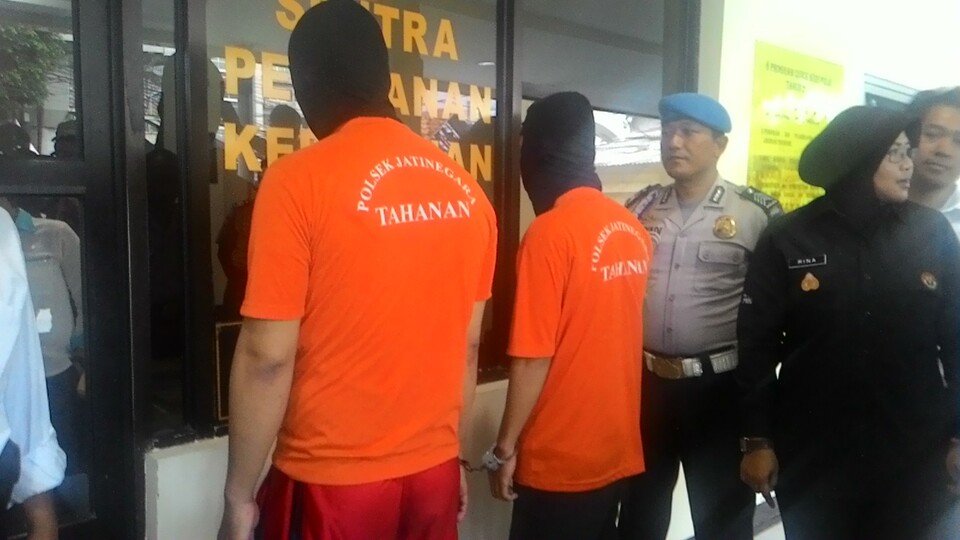 Dua pelaku pencurian bermodus pasangan sesama jenis saat berada di Polsek Jatinegara, Jakarta Timur, Senin (22/6).