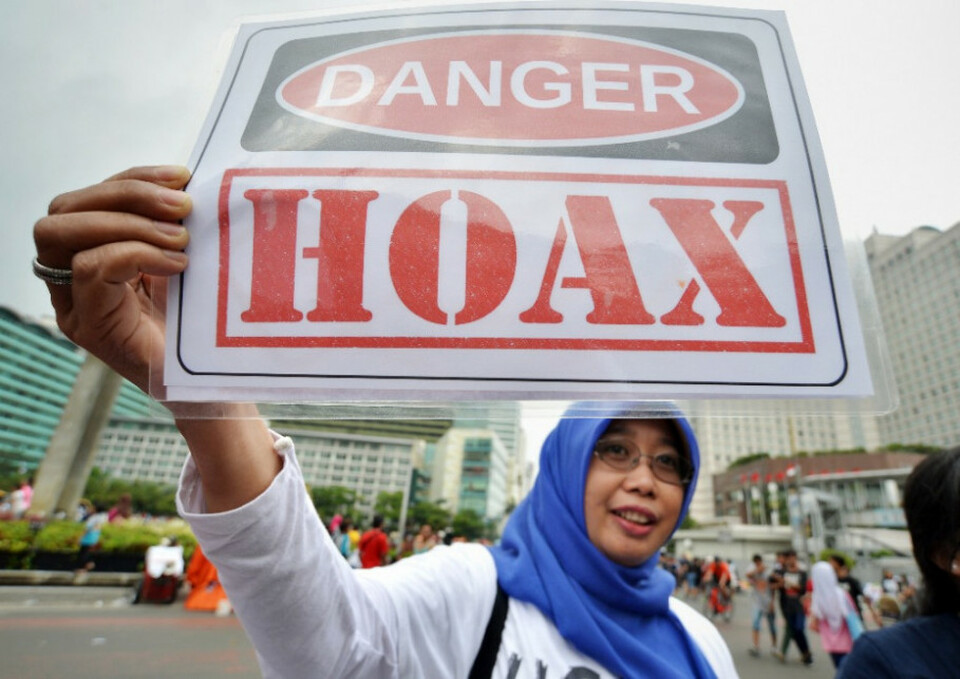 Aktivis yang tergabung dalam Masyarakat Anti-Fitnah Indonesia (Mafindo) membentangkan poster penolakan penyebaran berita bohong (