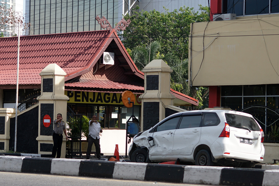 Mobil minibus yang digunakan pelaku teror dalam kondisi rusak di depan pintu masuk Mapolda Riau, di Pekanbaru, Riau, 16 Mei 2018.
