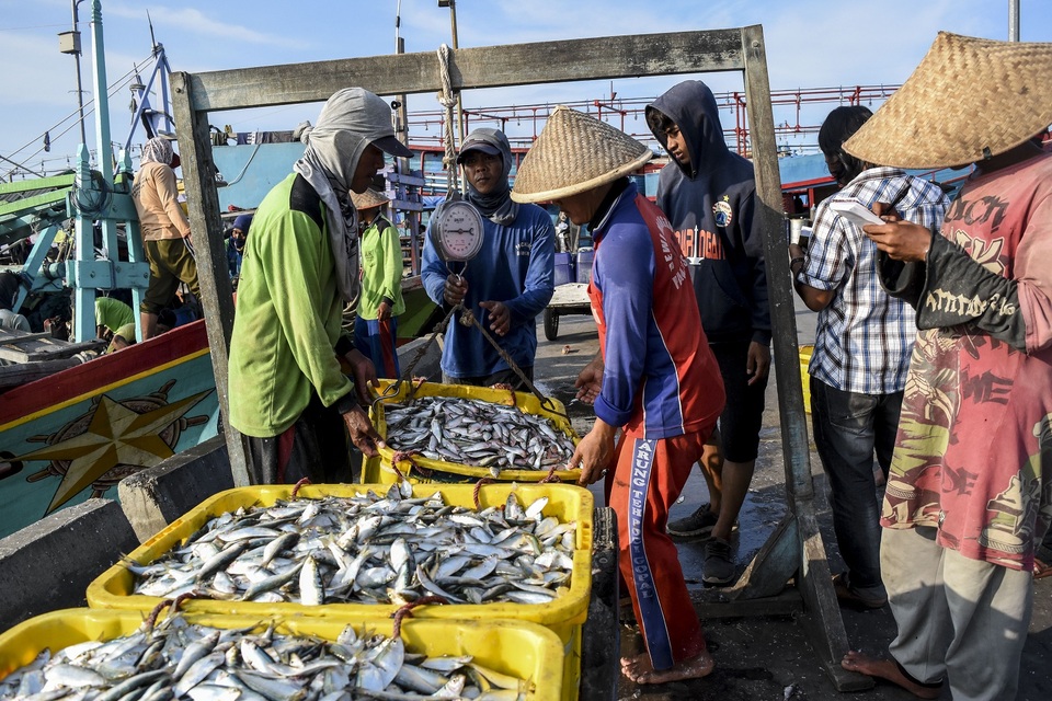 Nelayan menimbang ikan hasil tangkapan.