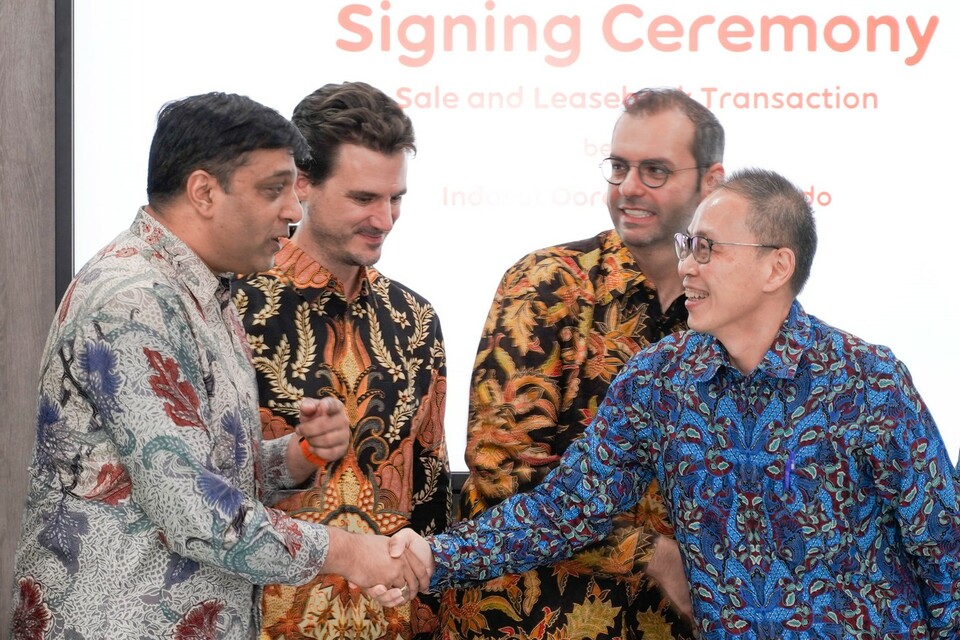 Director & Chief Operating Officer Indosat Ooredoo, Vikram Sinha (paling kiri) berjabat tangan dengan President Director Sarana Menara Nusantara and Protelindo, Ferdinandus Aming Santoso (paling kanan) saat penandatanganan perjanjian jual beli menara di Kantor Pusat Indosat Ooredoo, 14 Oktober 2019.